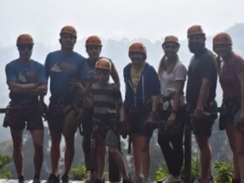 A group of hikers and zip liners standing for a picture in the mountains